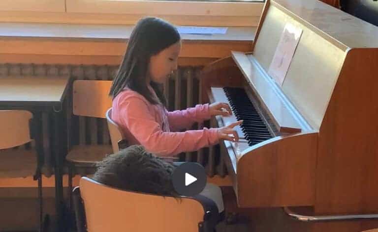 Screenshot von einem Mädchen am Klavier