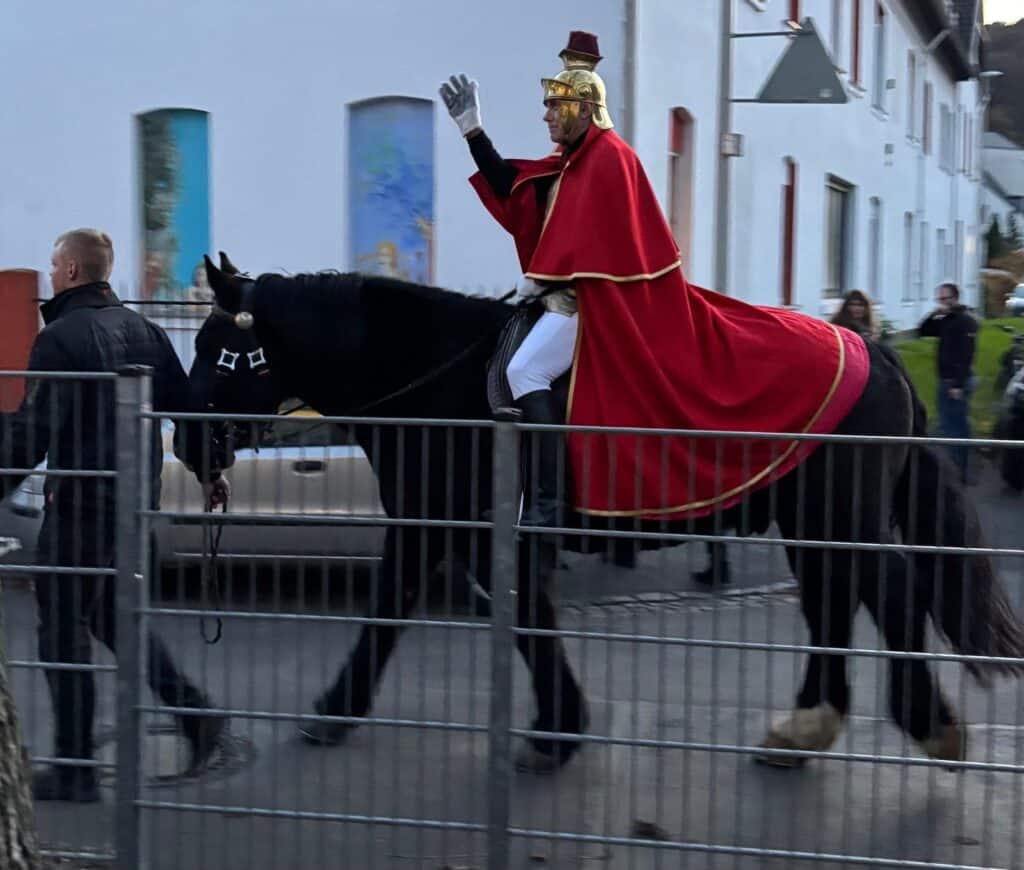 Sankt Martin reitet auf einem Pferd beim Martinszug der Servatiusschule